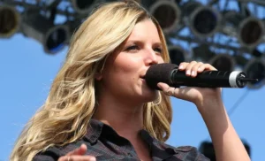 Jessica Simpson is singing with a microphone in her hand.