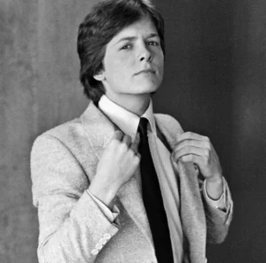 Michael J. Fox is standing wearing a coat.