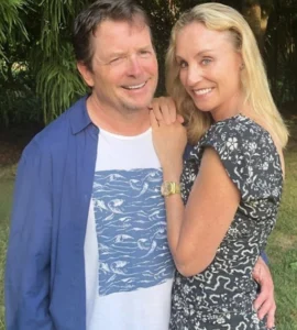 Michael J. Fox is standing next to the girl, laughing.