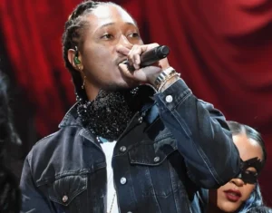 The girl from the future is standing behind him and singing into the microphone.