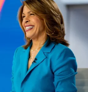 Hoda Kotb is laughing while wearing a blue coat.