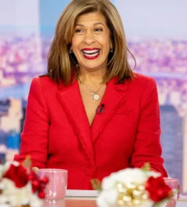 Hoda Kotb is doing her show wearing a red coat.