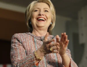 Hillary Clinton is laughing and clapping.