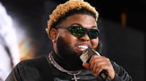 Droski is singing with a microphone in his hand.