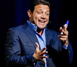 Jordan Belfort is talking with a pen in his hand.
