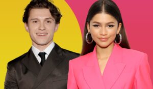 Man in a black suit and woman in a bright pink blazer smiling against a colorful yellow and pink background.